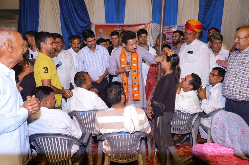 Col. Rajyavardhan Rathore actively addressing local citizens and coordinating with state officers at a grassroots public meet.