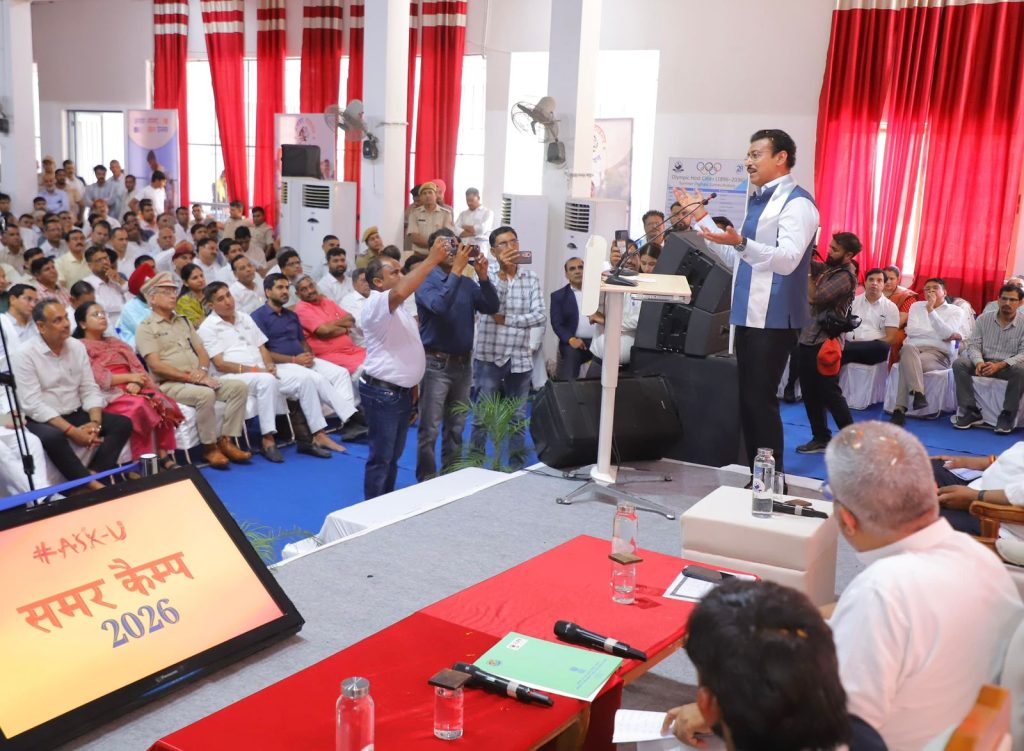 Sports Minister Col. Rajyavardhan Rathore interacting with young rural athletes on a newly upgraded village sports ground during a talent review.